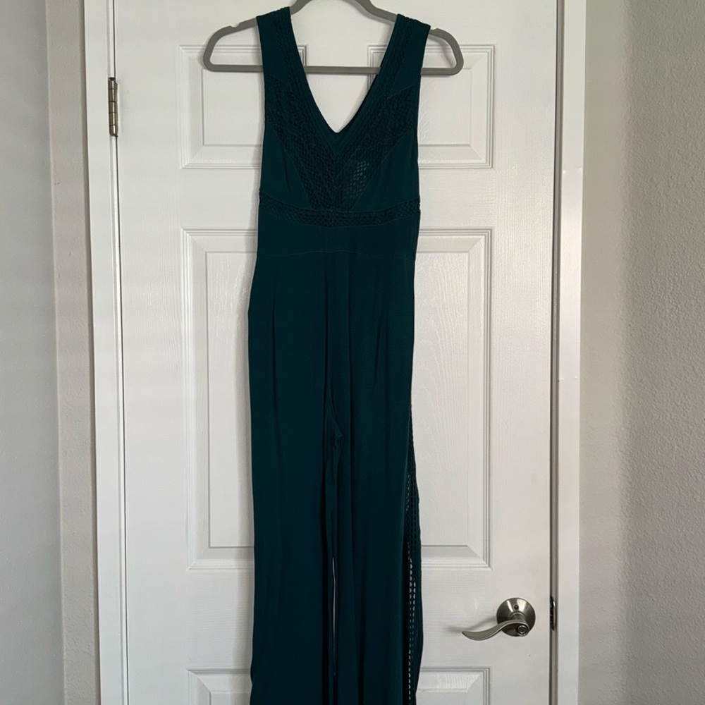 Dark turquoise green pantsuit with detailed top and side with tie in front.